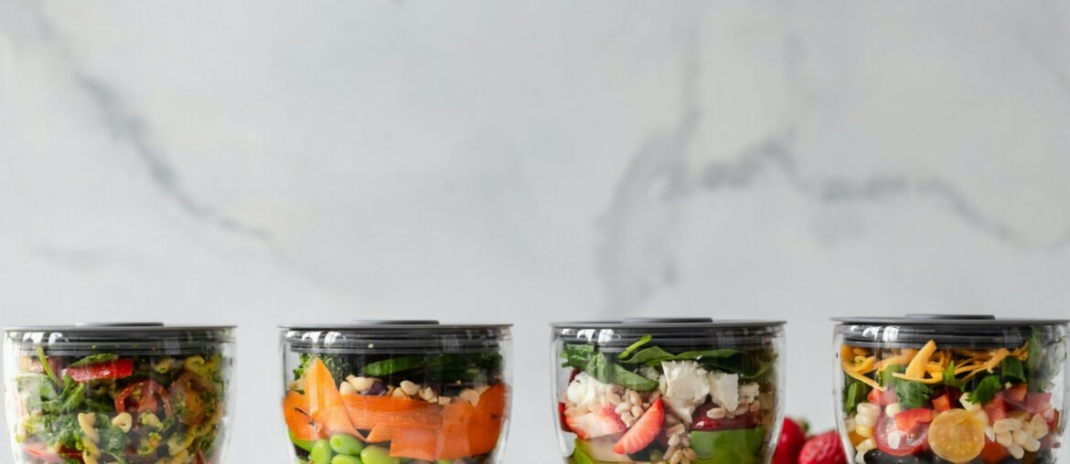 four clear plastic bowls with vegetables