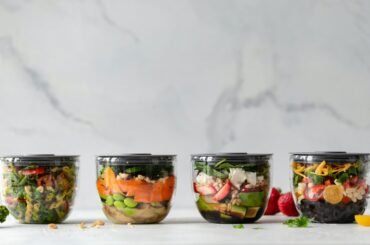 four clear plastic bowls with vegetables